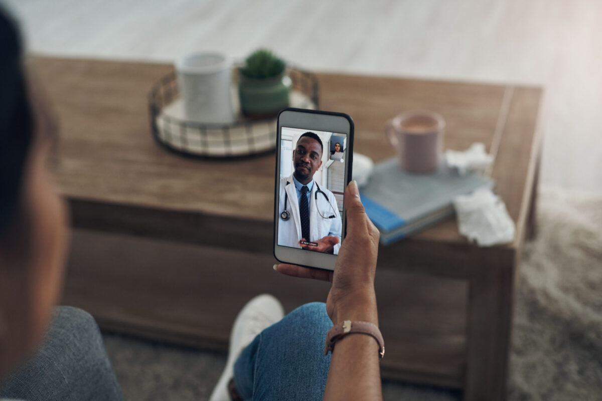 Person viewing a man in a doctor's coat on a cellular phone.