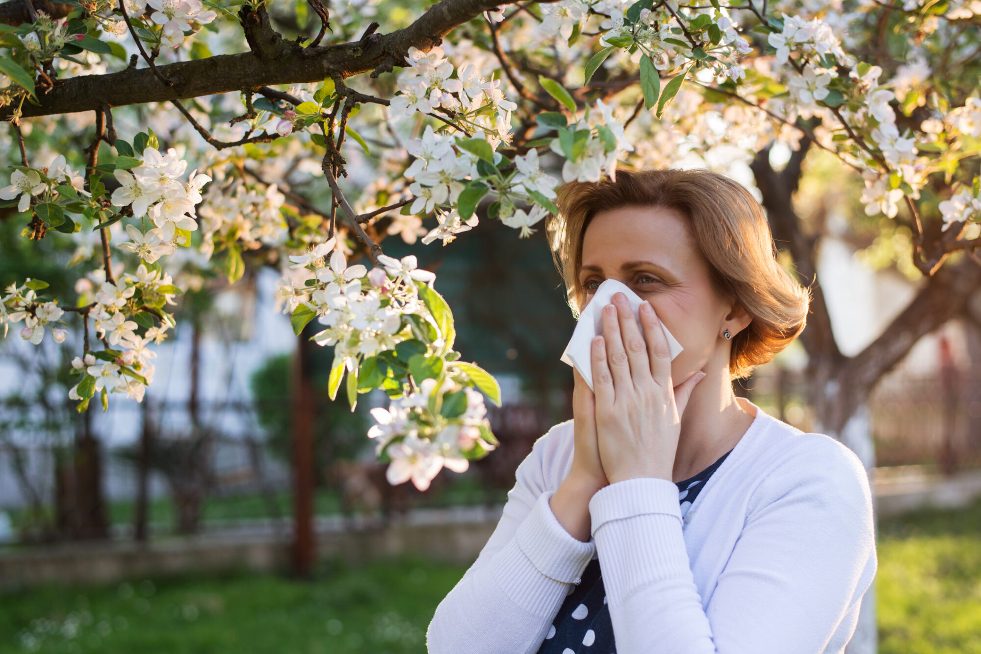Woman blowing nose with seasonal allergies in Louisiana